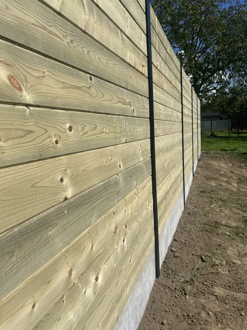 Houten tuinafsluiting met betonplaten geplaatst door Tuinwerken Kevin Wagelmans
